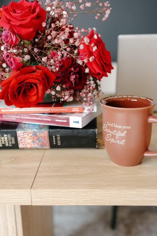 A warm welcome from ThriveWell &mdash; fresh roses beside advanced practice nursing texts in our Amherst, NY office
